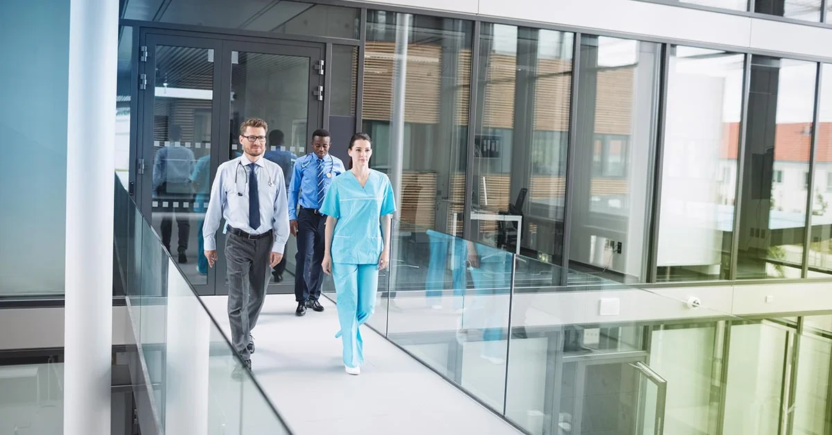 Clinical trial experts walking through a research facility building.