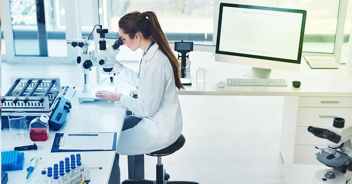 Laboratory researcher using microscope—symbolizing complexity and research demands in rare disease clinical trials.