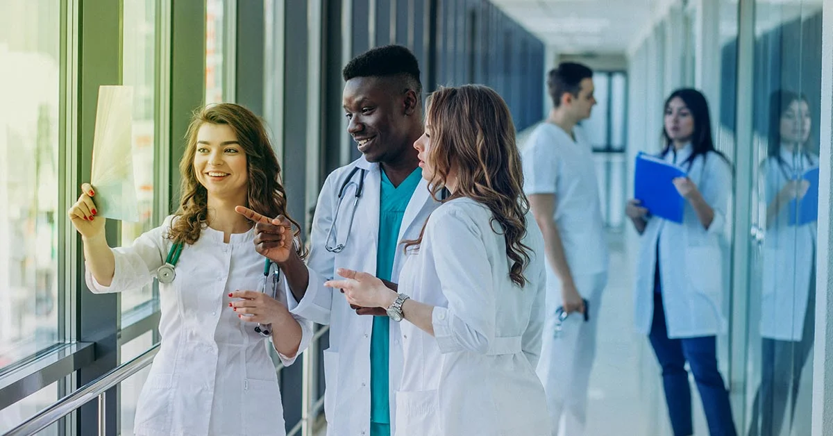 Medical researchers reviewing clinical trial documents related to the clinical trial design in a hospital corridor.